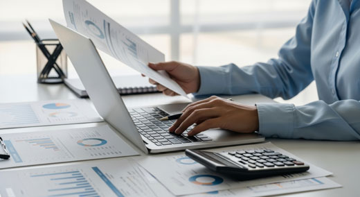 Jemand sitzend am Laptop der sich mit Finanzen beschäftigt